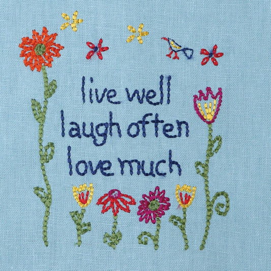 Peking Handicraft Live Well Pom Pom Kitchen Towel close-up of embroidered design with inspirational text and floral motifs