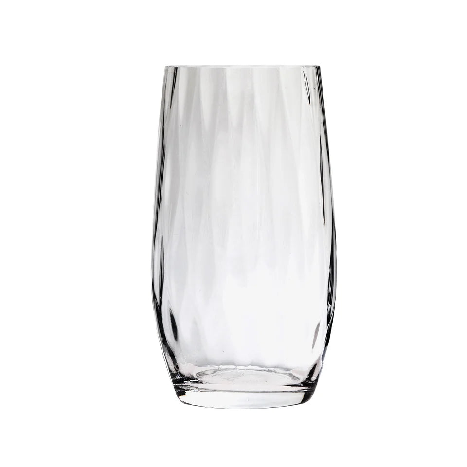 A clear, empty Skyros Designs "Abigail" glass tumbler with a faceted textured surface stands upright on a white background.