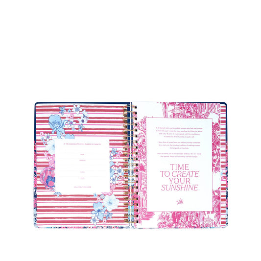 An open spiral-bound planner, the Lilly Pulitzer by Lifeguard Press - Jumbo 17 Month Agenda in "In All Her Glory," displays pink and white striped pages adorned with floral designs. On the right page, vibrant text reads "TIME TO CREATE YOUR SUNSHINE." Inspired by classic Lilly Pulitzer style, this hardcover agenda features a left page with spaces for personal information—ideal for keeping organized during your 2026-2027 planning.