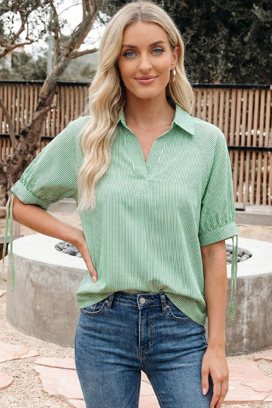66DISCO green and white striped split neck blouse worn with blue jeans, front view