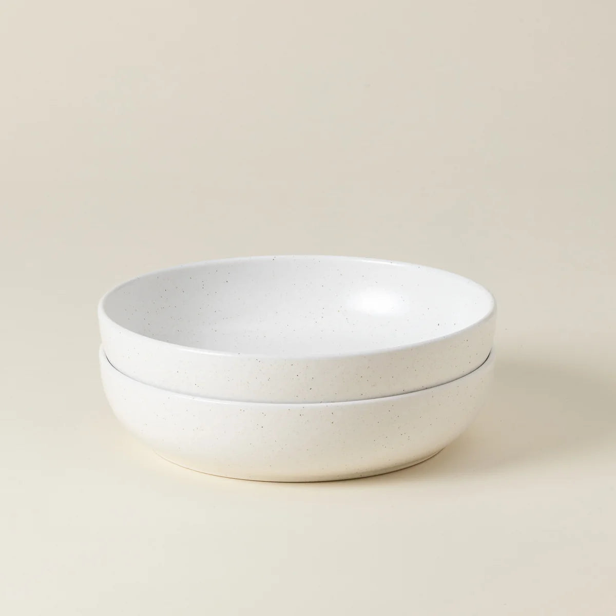 Two stacked Casafina “Pacifica - White” pasta bowls with a matte finish, displayed on a plain light beige background.