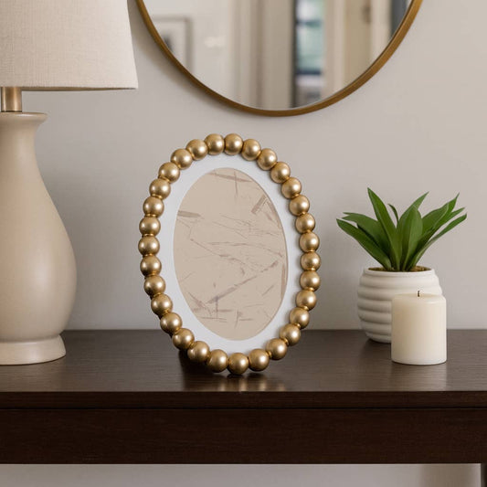 Sagebrook Home gold beaded oval photo frame displayed on shelf with white matted opening
