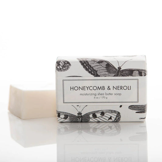 Formulary 55 Honeycomb & Neroli shea butter soap bar in cream next to illustrated packaging with black botanical motifs