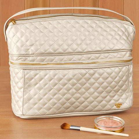 PurseN Stylist Travel Bag in cream quilted fabric with gold handles and dual zipper compartments, styled with makeup brush and eyeshadow