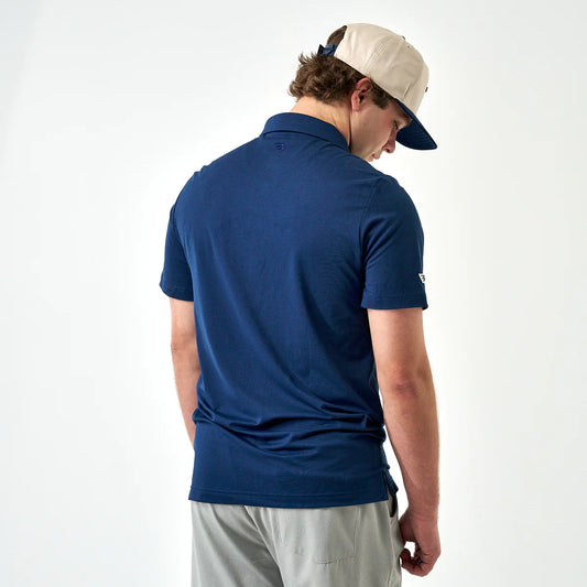 Burlebo Performance Polo in navy blue, back view worn with cream cap