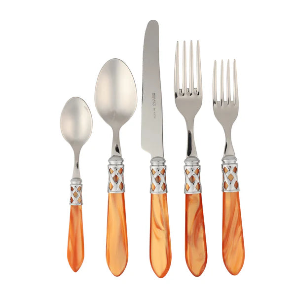 Five pieces of Vietri "Aladdin - Antique Rust" stainless flatware—one knife, two forks, and two spoons—with gleaming metal tops and orange marbled handles from Vietri, arranged side by side on a white background.