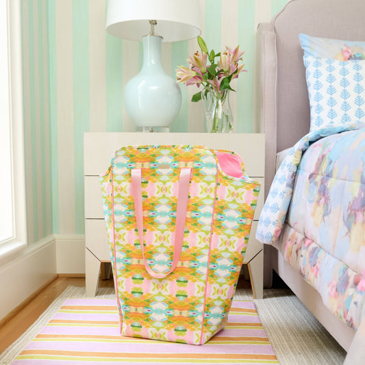 Laura Park Designs Palm Beach Laundry Bag styled in bedroom next to bed with striped nightstand