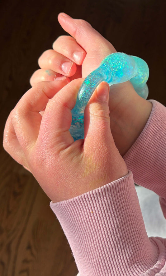 Feelzies Original Squishy Bracelet in turquoise glitter, worn on hand, showing gel texture