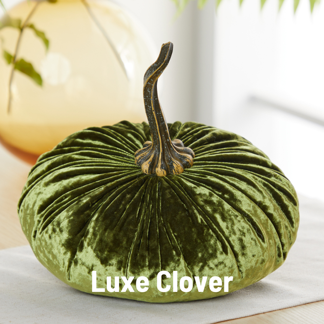 An extra large green velvet pumpkin from Your Heart’s Content, featuring a textured stem, sits on a table as an elegant wedding centerpiece. The words “Your Heart’s Content” are displayed in bold white letters at the bottom.