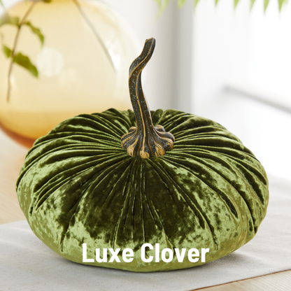 An extra large green velvet pumpkin from Your Heart’s Content, featuring a textured stem, sits on a table as an elegant wedding centerpiece. The words “Your Heart’s Content” are displayed in bold white letters at the bottom.