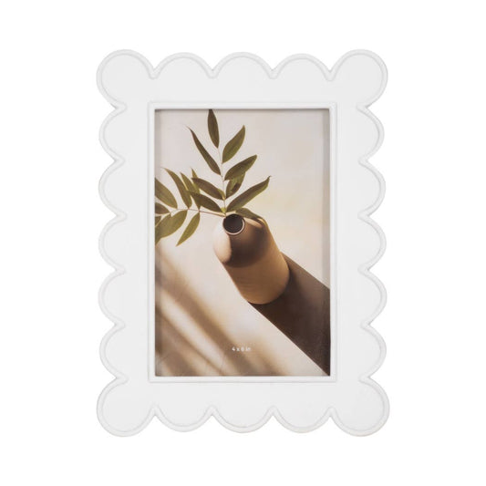 Sagebrook Home white scalloped resin frame holding portrait of hand holding potted plant with green leaves