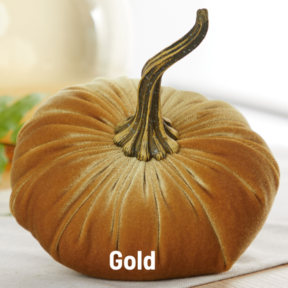 A large handcrafted velvet pumpkin from Your Heart’s Content, featuring a luxurious gold finish and a realistic stem, sits on a white surface—making it the perfect decor for your Thanksgiving centerpiece or fall mantel. The word “Gold” is displayed below the pumpkin.