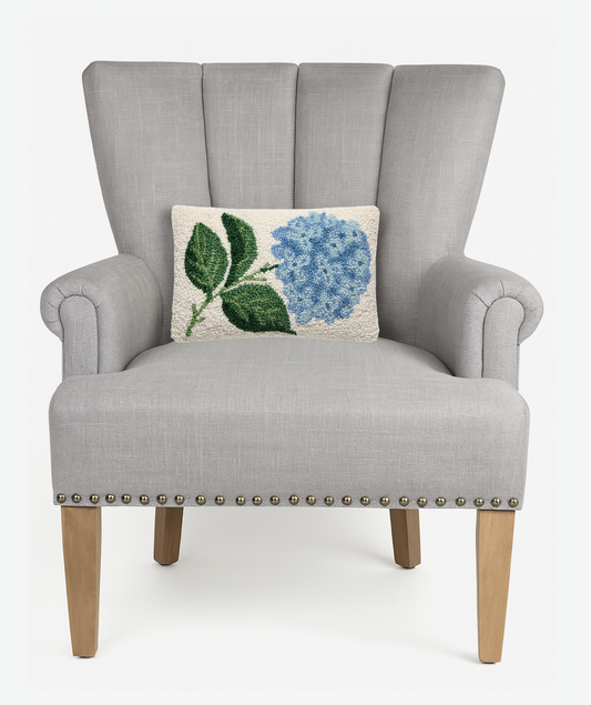 Hydrangea Hook Pillow displayed on gray upholstered wingback chair