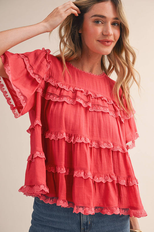 Woman wearing &MERCI tiered ruffle lace trim swing top in black with layered ruffles