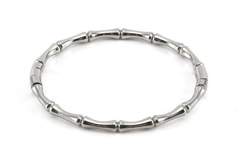 Mio Queena - Multi-style 18K Gold-plated Stainless Steel Bangle, featuring segmented, bamboo-inspired tube-like sections, is beautifully displayed on a white background—a striking bracelet from Mio Queena, ideal for jewelry gifts.