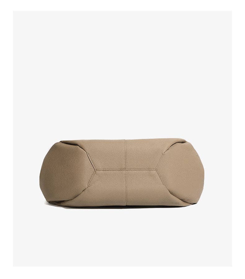 An Oyster-colored Brooklyn Tote by Parker & Hyde is pictured from the bottom, highlighting visible seams and a smooth textured surface against a plain white background.