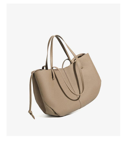 A Parker & Hyde Brooklyn Tote in Oyster, featuring two handles and a detachable shoulder strap, stands upright on a white background.