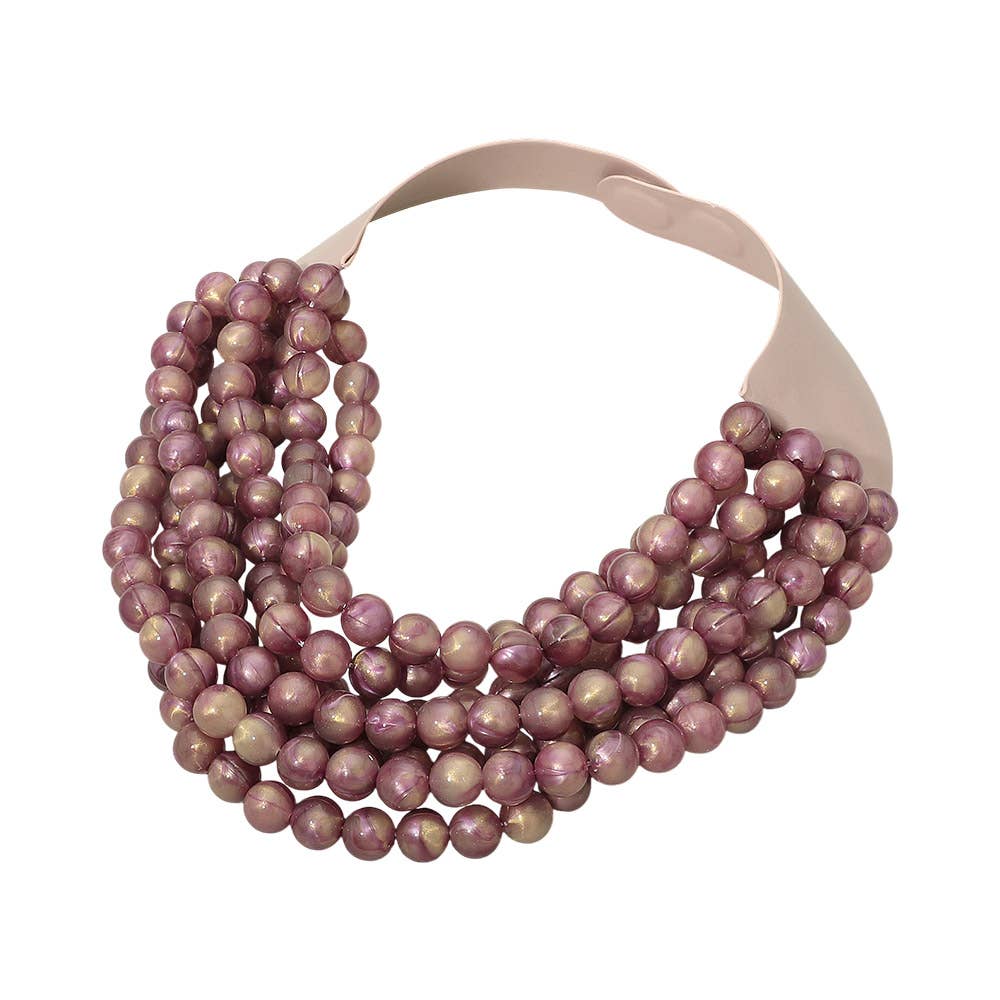 The Sensibling Corp. Marbled Ball Beaded Multi Layered Faux Leather Magnetic Collar Necklace features five strands of glossy, round, mauve-toned beads and a wide matching mauve clasp at the back. This bold statement piece from Sensibling Corp. brings effortless elegance to any outfit.