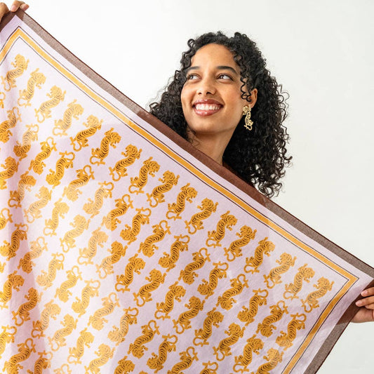 Person wearing INK + ALLOY Olivia tiger print scarf in lavender and gold