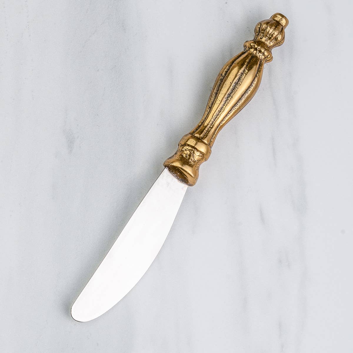 India Handicrafts gold ribbed spreader knife with ornate brass handle and white blade