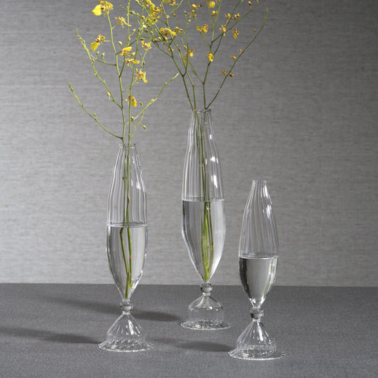 Three Zodax Flo Optic Glass Vases in varying heights filled with yellow flowers