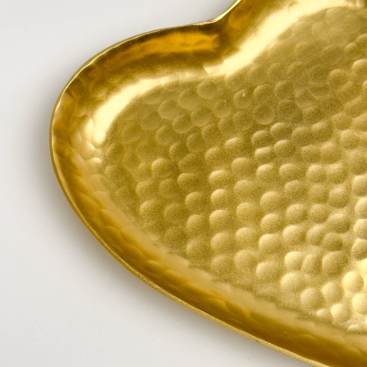 Close-up of hammered texture detail on gold heart tray