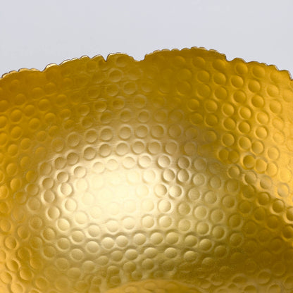 Gold hammered bowl detail showing textured circular indentation pattern across surface