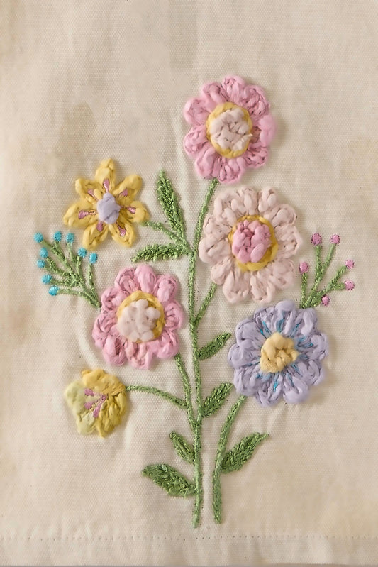 Close-up detail of Peking Handicraft Spring Floral Kitchen Towel showing textured embroidered flowers in pink, yellow, lavender, and cream