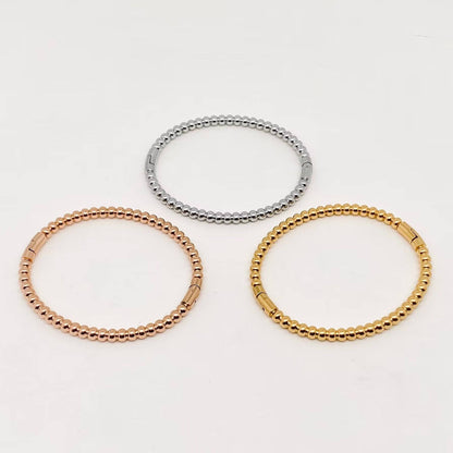 Three 4mm beaded metal snap bangles from Mio Queena—crafted with gold plated, rose gold, and silver stainless steel—are arranged in a triangular pattern on a plain white background, making the Mio Queena bangles ideal as elegant jewelry gifts.