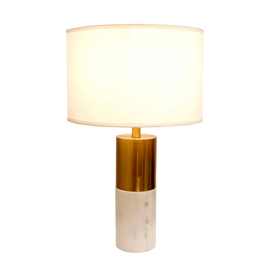 Pasargad Home Rhoda table lamp illuminated, showing warm light through cream fabric drum shade