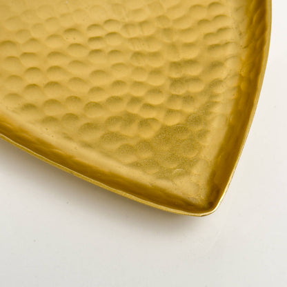 Hammered surface detail of gold heart tray at angle