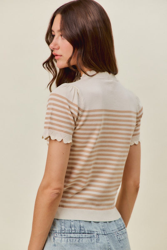A woman with long brown hair, seen from behind, models the So Me Striped Lightweight Sweater by So Me—a beige and white striped casual top with scalloped sleeves—paired with light blue jeans.