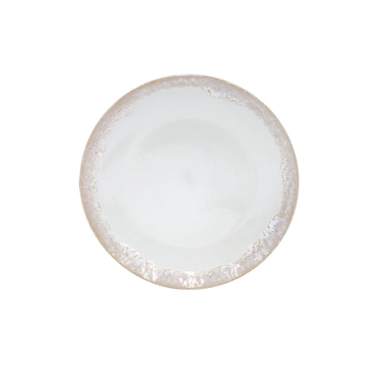 The Costa Nova “Taormina” Dinner Plate by Costa Nova is a white ceramic plate with a textured, slightly raised, light beige rim, shown from above against a plain white background.