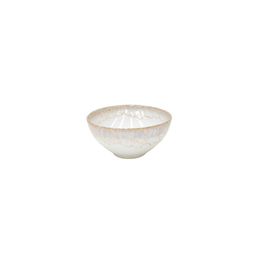 The Costa Nova “Taormina - White” Cereal Bowl features a white, slightly textured ceramic surface accented by a subtle light brown rim, shown against a plain white background.
