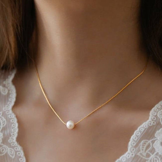 JOSSLYN by wall to wall 18K stainless steel pearl necklace worn close to neck, featuring single white pearl on delicate gold chain