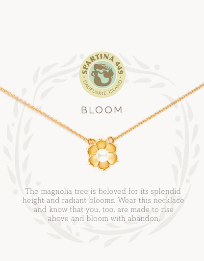 The Spartina Sea La Vie Bloom Necklace features a gold magnolia flower pendant on a delicate chain, displayed above the word "BLOOM" and an uplifting message about the magnolia tree's beauty and symbolism of rising above. This inspirational jewelry piece from Spartina captures both elegance and meaningful encouragement—a beautiful magnolia necklace designed to remind you to shine. The Spartina logo appears at the top.