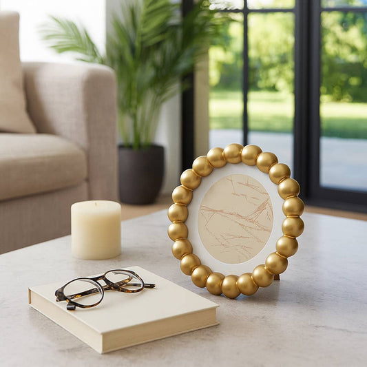 Sagebrook Home gold beaded frame with white matted center on table with candle and glasses