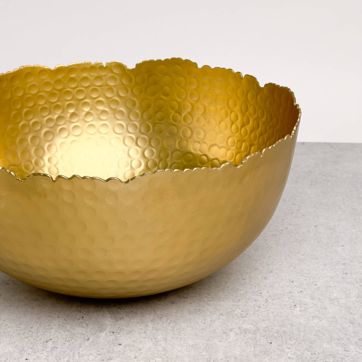 India Handicrafts Inc Large Gilded Hammered Bowl angled side view highlighting dimensional hammered texture