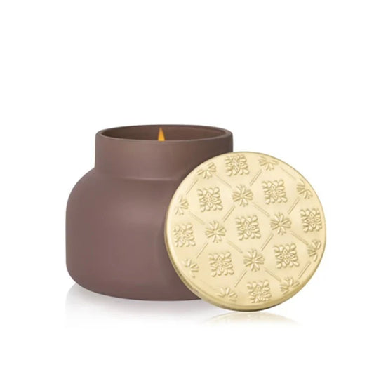 Capri Blue Artisan Terrazza Velluto taupe candle with lit flame and gold embossed lid