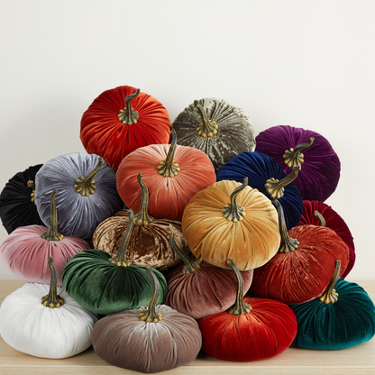 A collection of “Your Heart’s Content - Pumpkin Extra Large Velvet” pumpkins by Your Heart’s Content, available in a range of colors such as red, orange, purple, green, gold, grey, and white, beautifully arranged on a wooden surface with a plain white background—ideal as seasonal mantel décor or an elegant centerpiece for weddings.