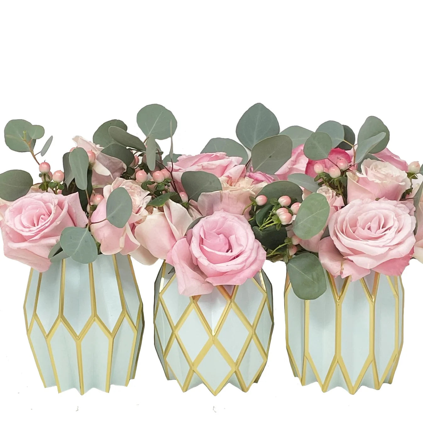 Three Tiffany blue and gold Vase Wraps by Lucy Grymes hold pink roses, green leaves, and small pink berries, arranged side by side against a white background.
