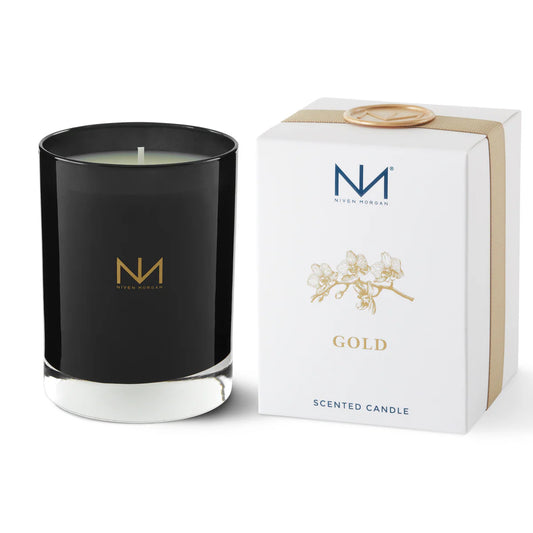 Niven Morgan Gold scented candle in black glass with white base and white box with tan ribbon