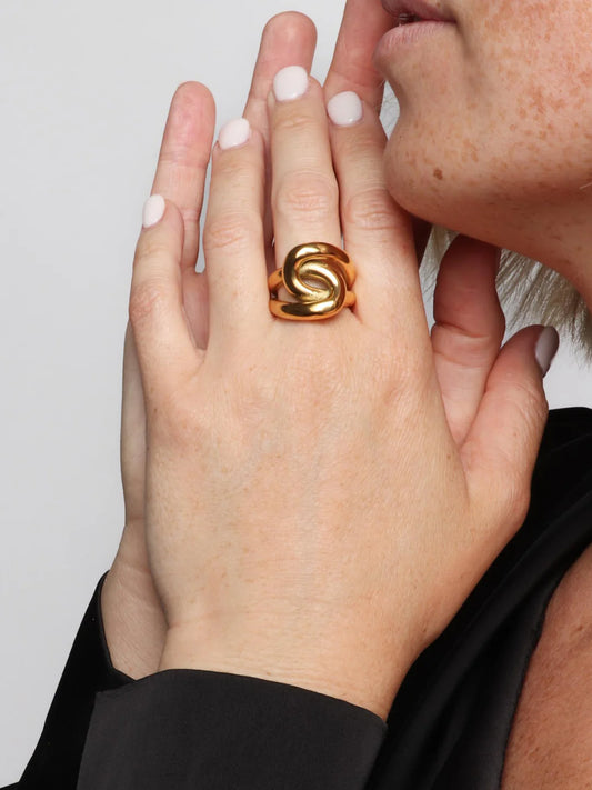Marrin Costello Cobra Ring worn on finger, gold snake-like statement band
