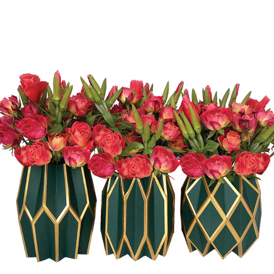 Three Vase Wraps by Lucy Grymes in forest green with gold accents, each holding vibrant red and pink roses with green leaves, arranged side by side against a white background.