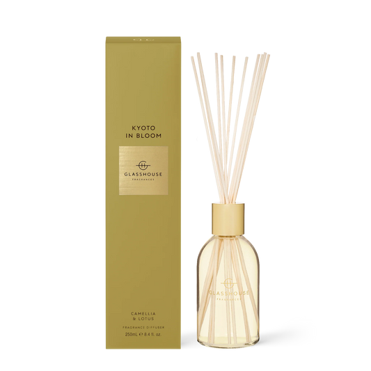 Glasshouse Kyoto In Bloom diffuser with gold cap and cream reeds next to olive-green box