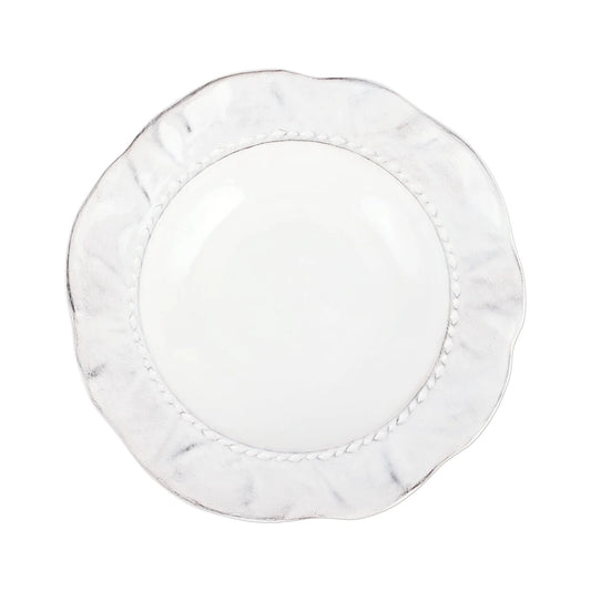 A round, white ceramic Vietri “Giorno - Ash” Pasta Bowl with a wavy, textured rim and a subtle decorative pattern near the edge is shown on a white background.