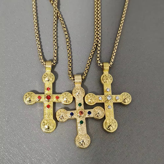 Three Coastal Grit Marion Cross Necklaces in gold with colorful crystal embellishments hanging on chains