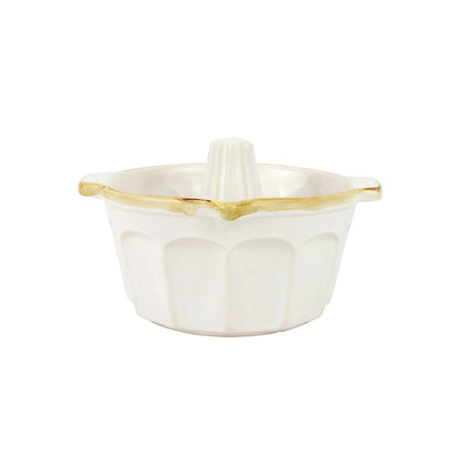 The Vietri Italian Bakers White Bundt Pan by Vietri is a white ceramic pan with a fluted design and a gold rim along the top edge, crafted from durable Italian stoneware, displayed on a plain white background.