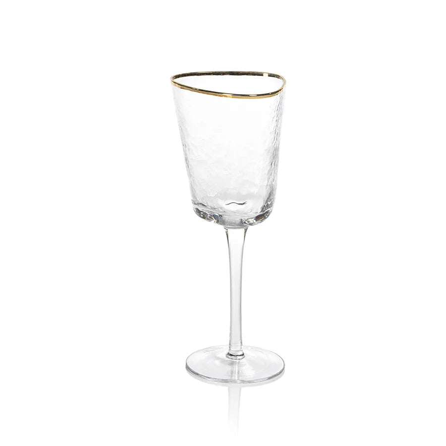 The Zodax "Kampari" wine glass features a clear, tall silhouette with a subtly textured surface and a delicate gold rim, displayed against a plain white background.