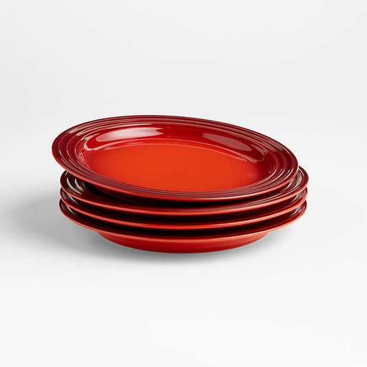 Stack of four Le Creuset cerise red pasta plates in glazed stoneware